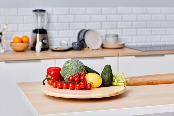 Frisse schaal met groenten op een lichte tafel in een rustige keukenomgeving
